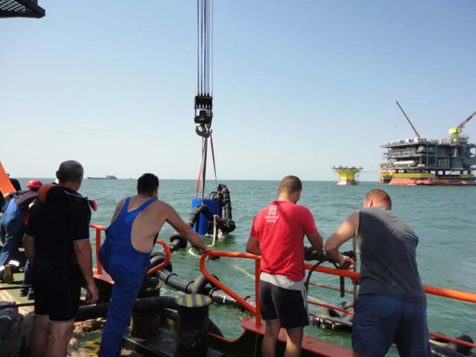 Бригада на палубі біля борту стежить за підйомом